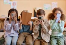 Nationwide Kid Ban Sparks Digital Uproar Four children sitting together, each focused on their electronic devices
