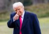 Trump Accounts Offer Kids A $1,000 Start A man in a dark coat and pink tie giving a thumbs up outdoors