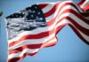 Waving American flag against a clear blue sky