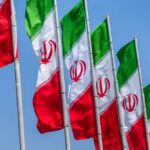 The Hidden Battle Behind The Tournament Multiple Iranian flags waving against a clear blue sky
