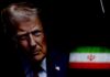 Blockade Lifted—Binding Terms Missing? Close-up portrait of a man with a serious expression, with the Iranian flag in the background