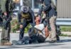 Law enforcement officers apprehending a suspect on the ground