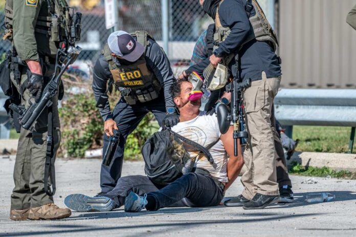 Law enforcement officers apprehending a suspect on the ground