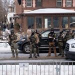 Law enforcement officers in tactical gear at a crime scene in winter