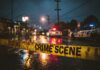 The Public Safety Question Nobody Can Ignore Police cars at a crime scene with caution tape in the foreground