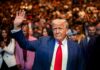 Historic Rewrite Looms — What Gets Deleted? A man in a suit waving to a crowd at a public event