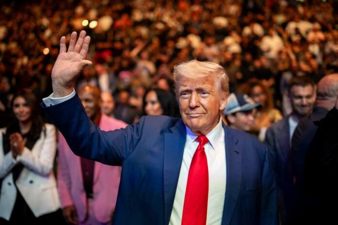 President,Donald,Trump,Attends,Ufc,316,At,The,Prudential,Center A man in a suit waving to a crowd at a public event