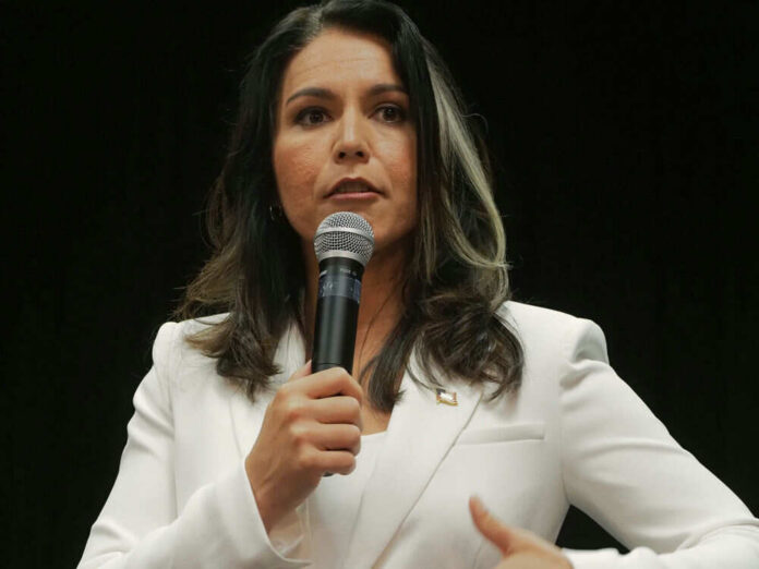 tulsigabbardid1597391320jpg Woman in white suit speaking into a microphone