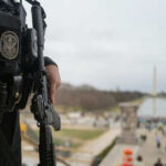 Officer holds rifle overlooking National Mall event