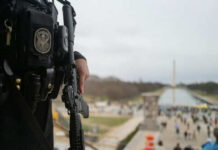 Officer holds rifle overlooking National Mall event