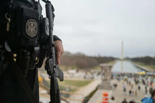 Officer holds rifle overlooking National Mall event