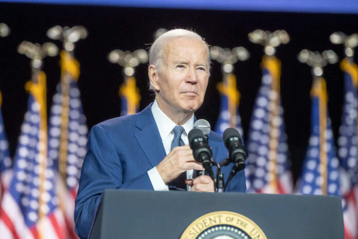 656000984 Man speaking at podium with American flags behind.