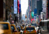 Charlie Kirk Returns To Times Square Busy city street with taxis and billboards daytime