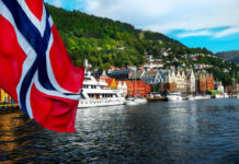 Norway Pulled Off an Unforgettable Upset Norwegian flag over harbor with colorful waterfront buildings and boats