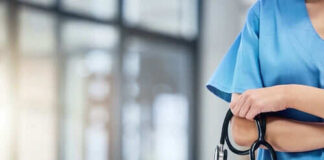 Healthcare professional holding a stethoscope in hospital