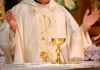Priest celebrating Mass with chalice and open hands
