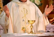 A New Divide Emerges Inside The Catholic Church Priest celebrating Mass with chalice and open hands