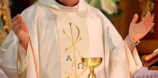 Priest celebrating Mass with chalice and open hands