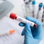 Where Did America’s Foreign Aid Really Go? Gloved hand holding a blood sample tube labeled for HIV test
