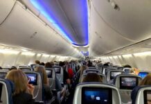 A Routine Workday Took An Unexpected Turn Airplane cabin with passengers seated and seatback screens