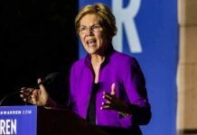 Democrats Press Trump Library Over Missing Millions Person speaking at a podium in a purple jacket