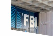 FBI sign on building facade behind metal fence