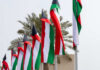 Kuwait’s Water Lifeline Comes Under Attack Multiple flags waving in the wind with palm trees in the background
