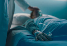 A Comforting Pattern Near Life’s End A medical professional attending to a patient in a hospital bed