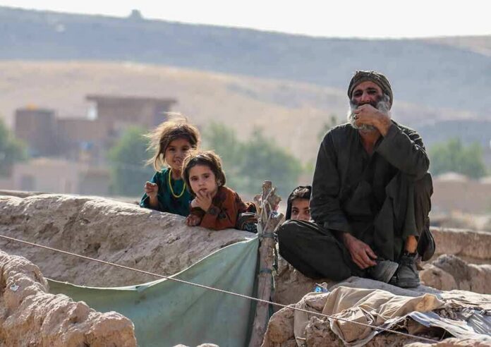 shutterstock_2025653837 Group of people sitting by a low earthen wall