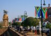South African flags line a walkway near a bronze equestrian statue