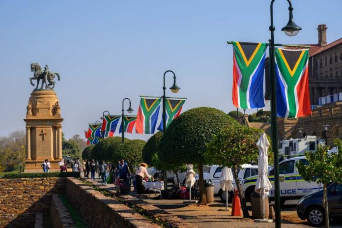 Pretoria,,South,Africa,-,June,21,,2024:,South,African,Flags South African flags line a walkway near a bronze equestrian statue