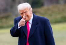 A Historic Launch For America’s Next Generation A man in a dark coat and pink tie giving a thumbs up outdoors