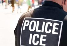 Close-up of a police officer's back with a 'POLICE ICE' badge