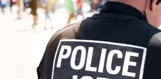 Close-up of a police officer's back with a 'POLICE ICE' badge