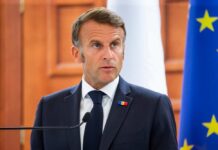 Europe’s Security Gamble Enters A New Phase A political leader speaking at a press conference with flags in the background