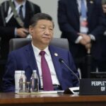 Senior official in a blue suit sits at an international conference table