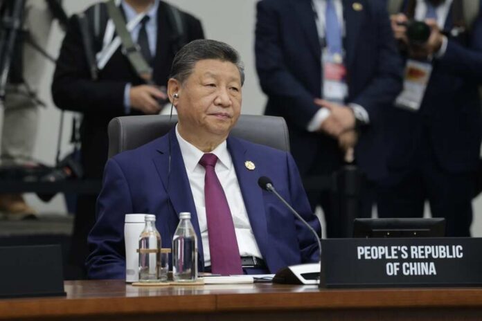 Senior official in a blue suit sits at an international conference table