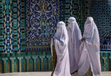 Mosque–Boarding School Sparks Island Uproar Three women in white veils walking past ornate blue tilework