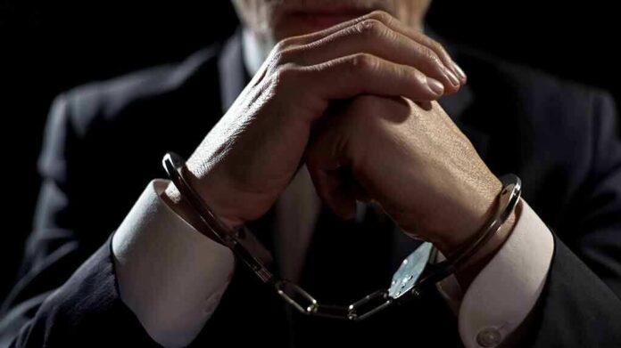 shutterstock_1068932513 Businessperson in handcuffs with hands clasped