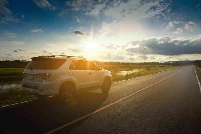 White SUV parked on a rural road at sunset