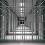 empty prison corridor with barred cells