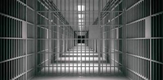 empty prison corridor with barred cells