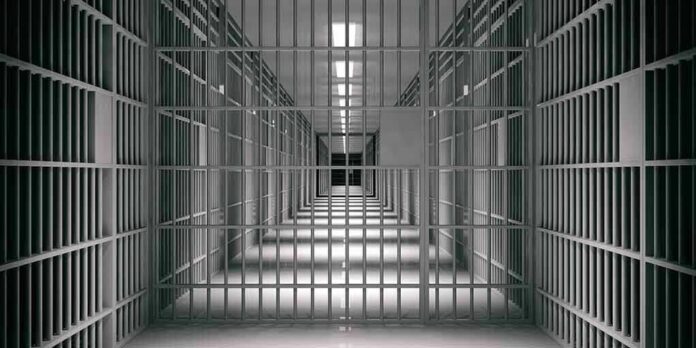 empty prison corridor with barred cells