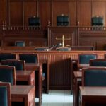 Empty courtroom with wooden benches and judge's bench