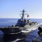 naval destroyer sailing at sea with flag flying