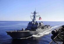naval destroyer sailing at sea with flag flying