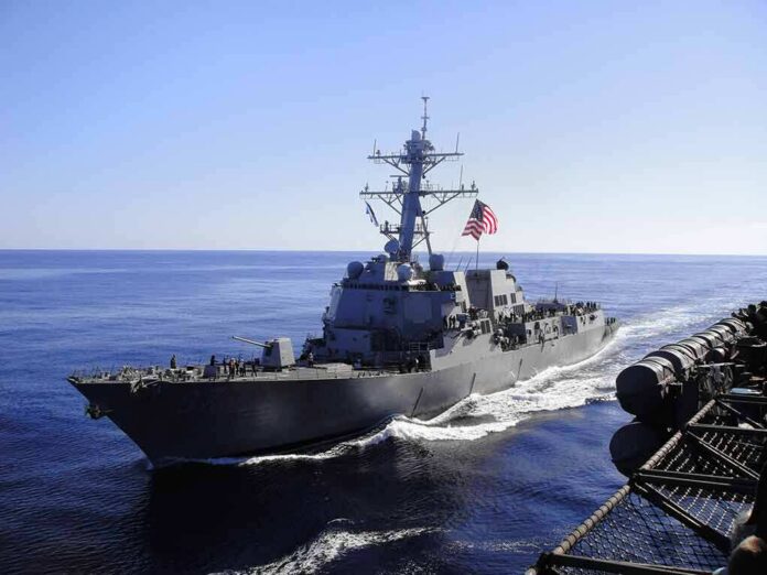 naval destroyer sailing at sea with flag flying