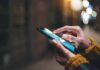 Hands using a smartphone outdoors at night