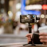 Smartphone on a handheld gimbal filming a city street at night