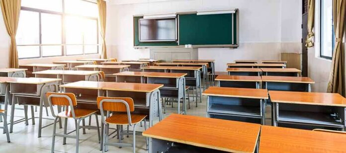 Empty classroom with rows of desks and a chalkboard